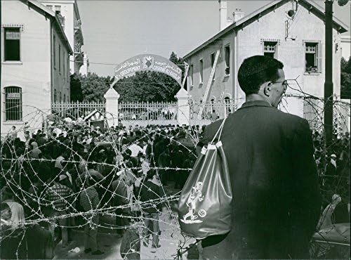 תצלום וינטג 'של אדם המשקיף על התכנסות ענקית של אנשים באלג'יריה, 1963.
